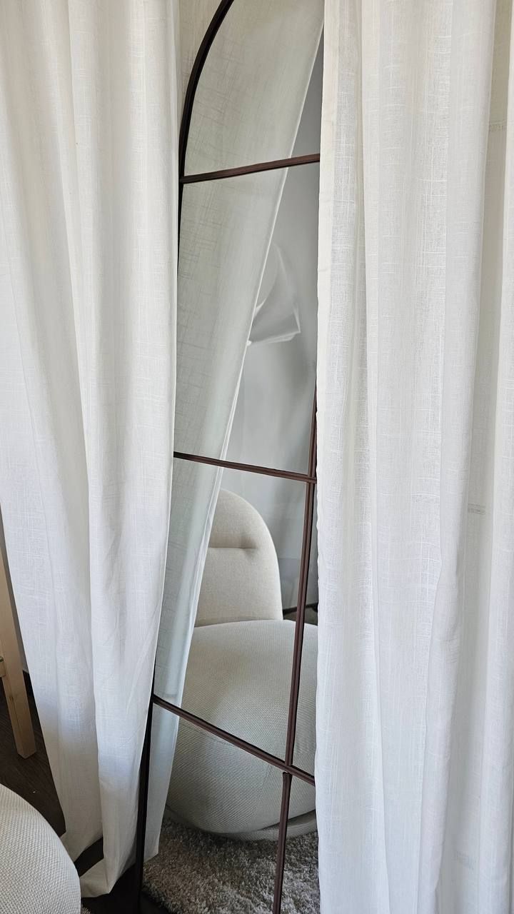 Interior zone with arched mirror, linen curtains and armchair